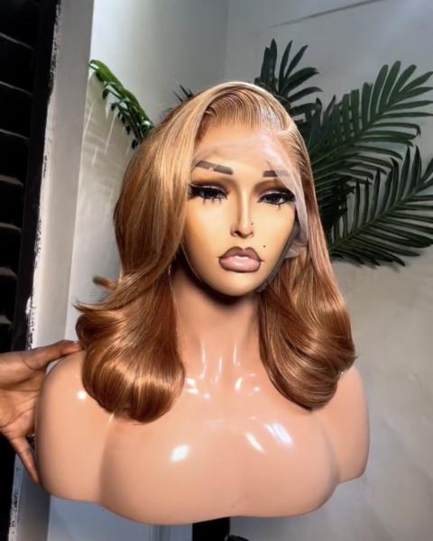 A honey-brown, layered wavy lace frontal wig